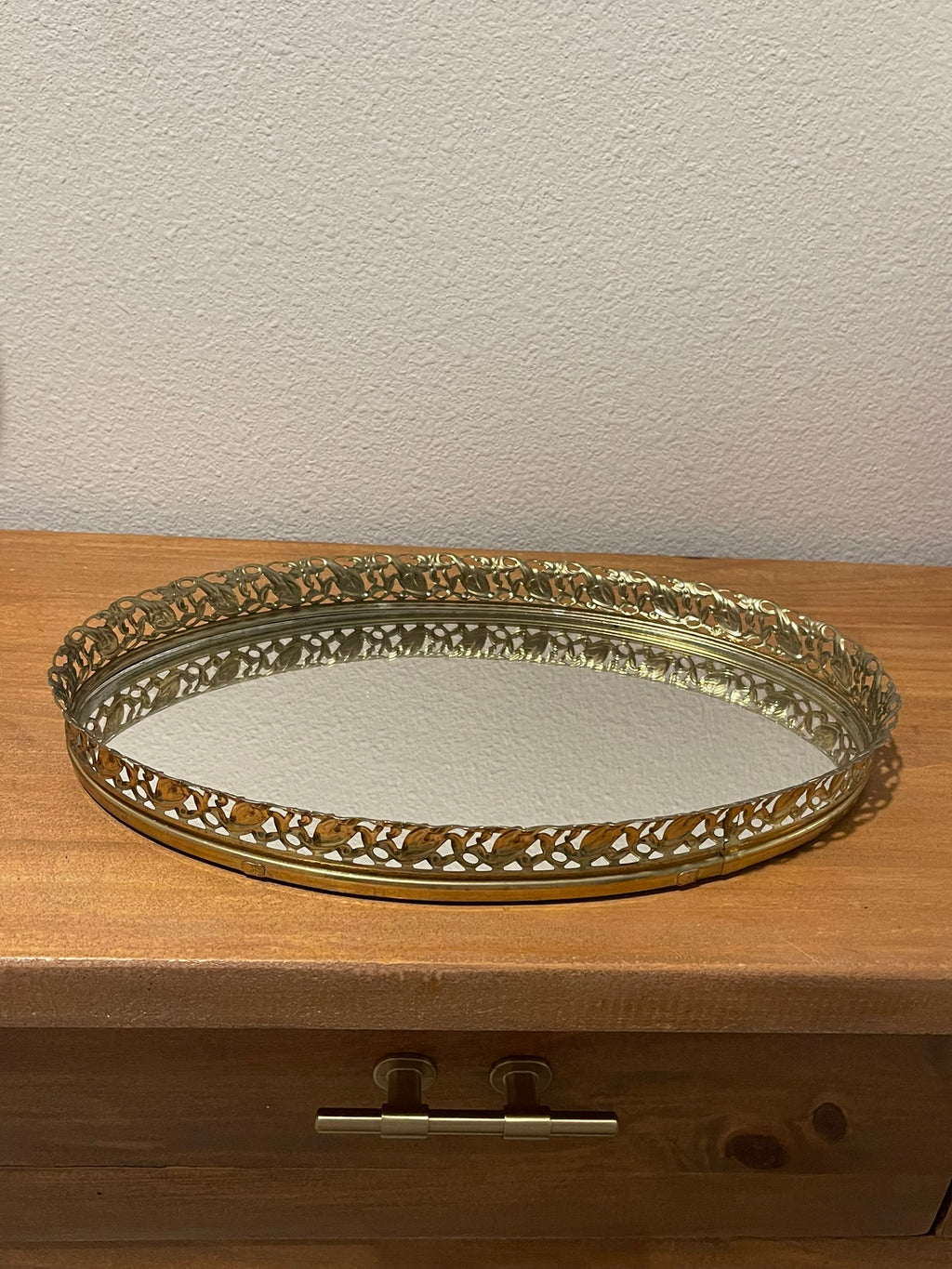 Vintage gold filigree oval mirror vanity tray, angled side view showing mirror surface and rim depth