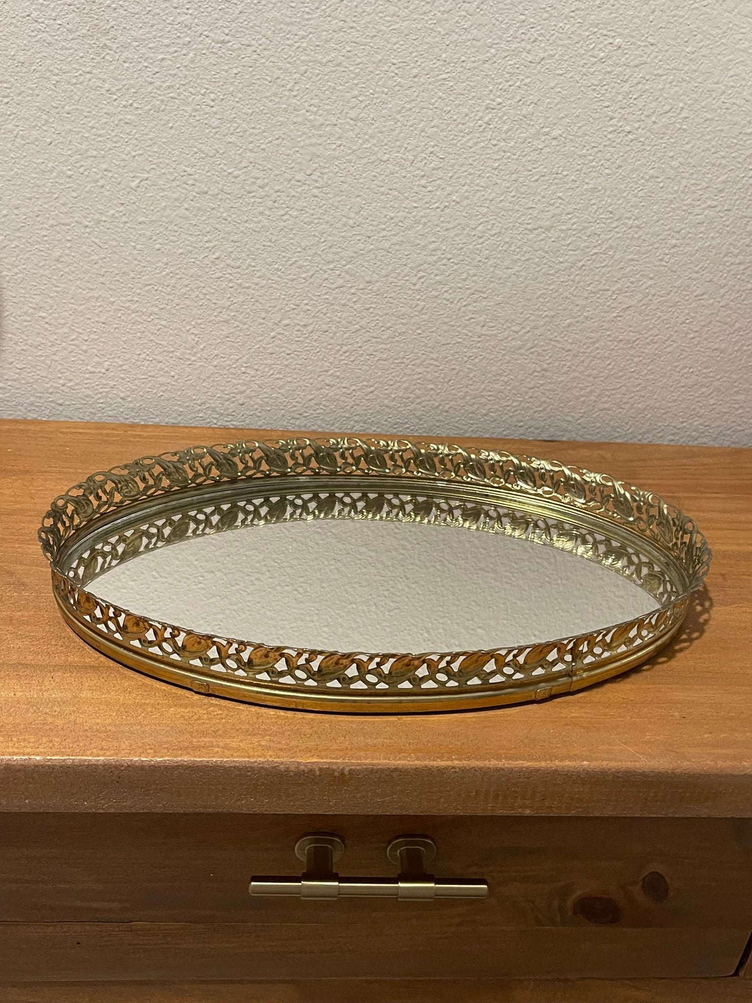 Vintage gold filigree oval mirror vanity tray, angled side view showing mirror surface and rim depth