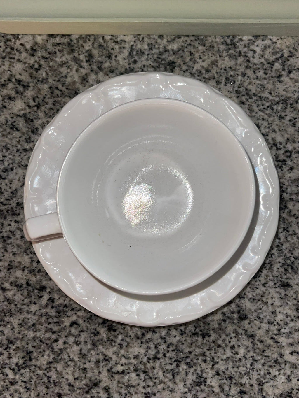 Top-down view of Gibson white embossed teacup and saucer
