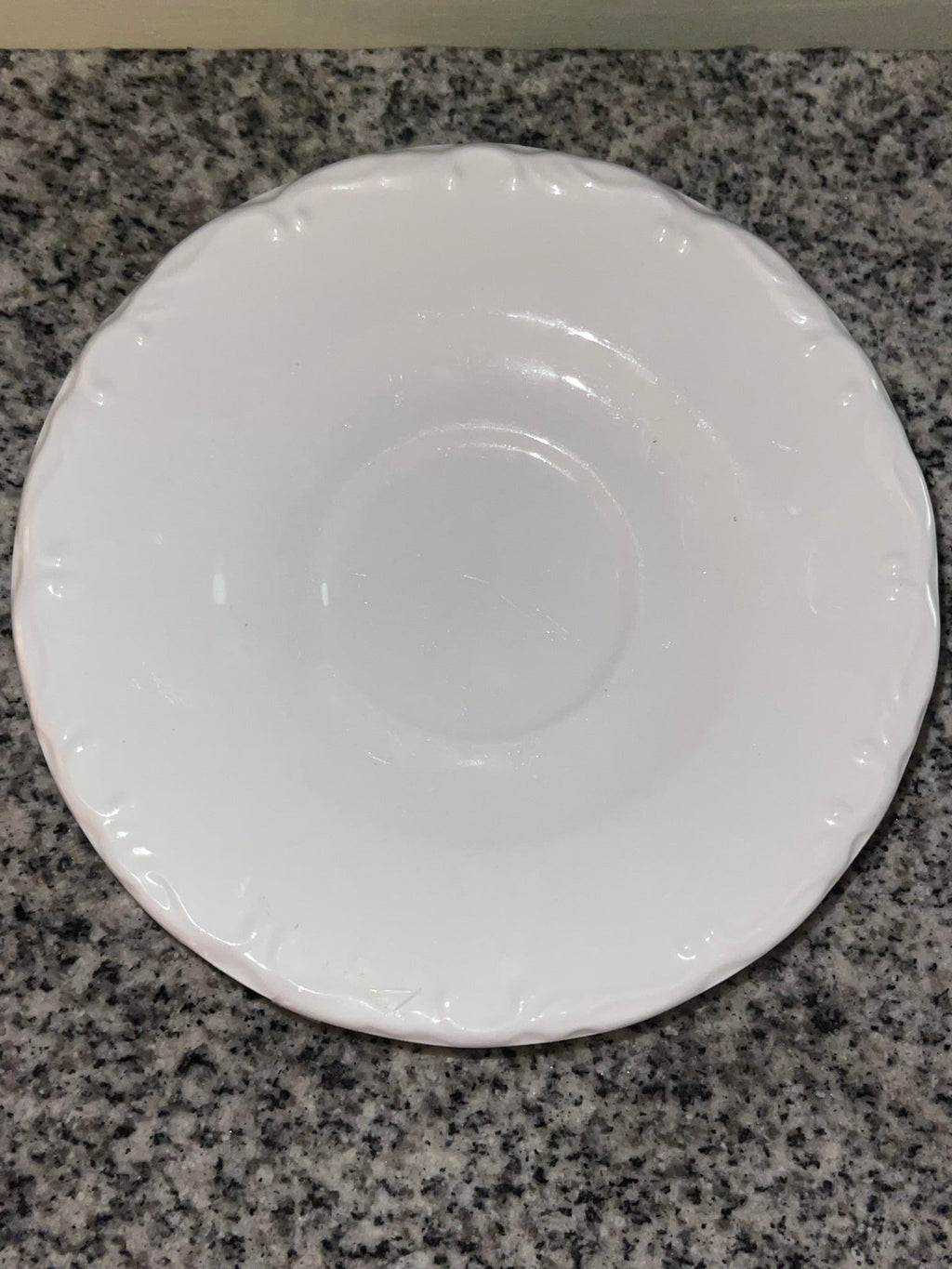 Top-down view of Gibson white embossed saucer showing scalloped edge