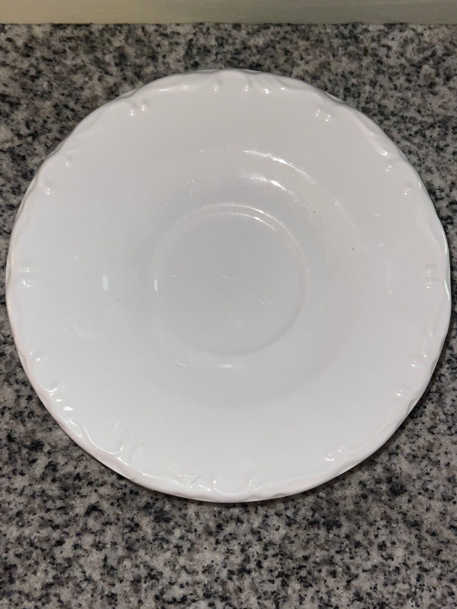 Top-down view of Gibson white embossed saucer showing scalloped edge