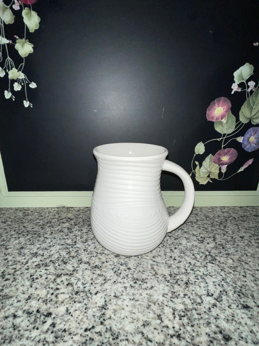 Temp-tations by Tara white ribbed 16 oz mug, front view with floral background