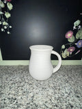 Temp-tations by Tara white ribbed 16 oz mug, front view with floral background