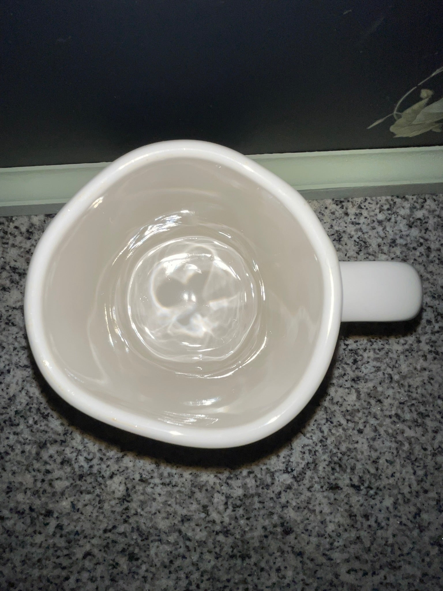 Top-down view of Rae Dunn HAPPY mug showing clean white interior