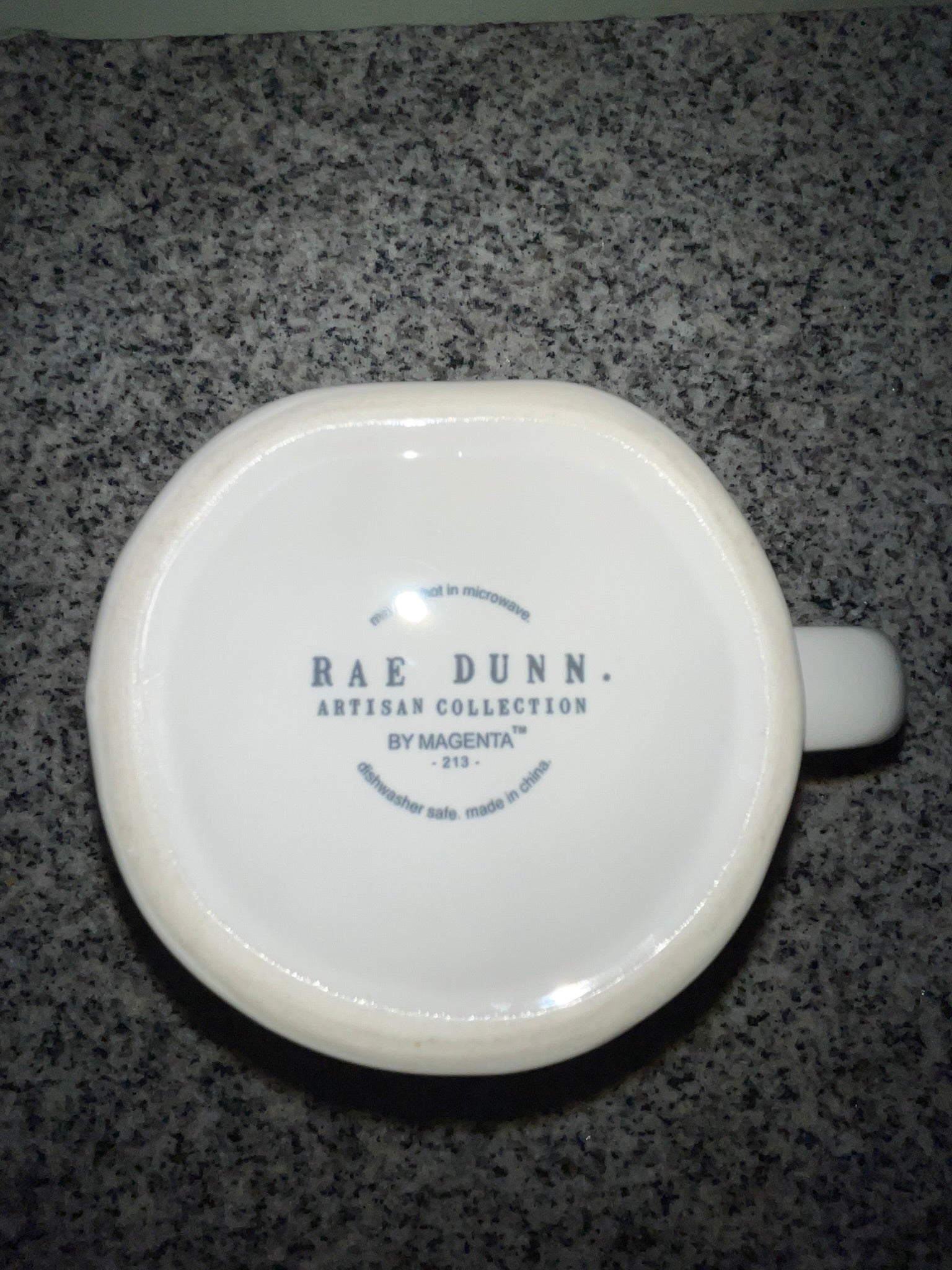 Bottom of Rae Dunn HAPPY mug showing Artisan Collection by Magenta backstamp, dishwasher safe