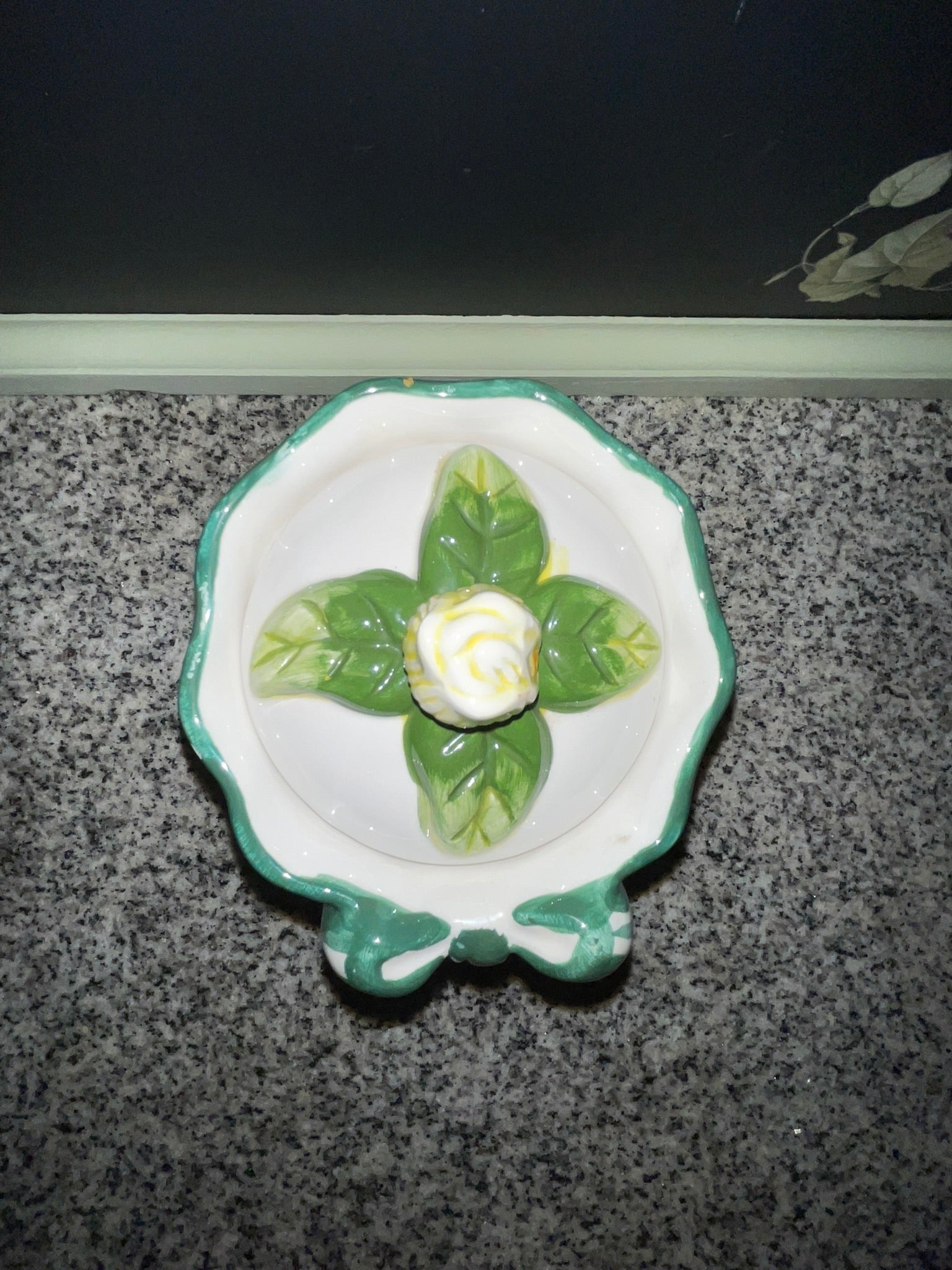 Top view of NINS cookie jar lid showing scalloped leaf form and rosebud finial