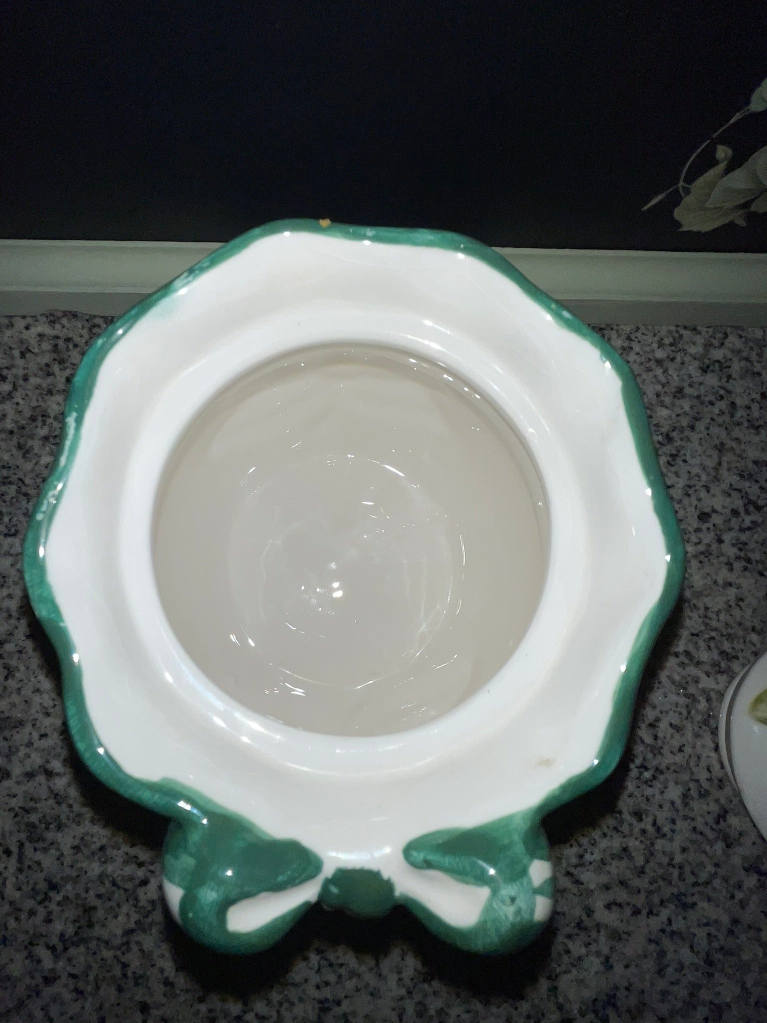 Underside of NINS cookie jar lid showing interior and teal bow detail