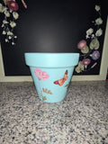 Aqua blue botanical planter showing pink rose and butterfly decoupage, front view