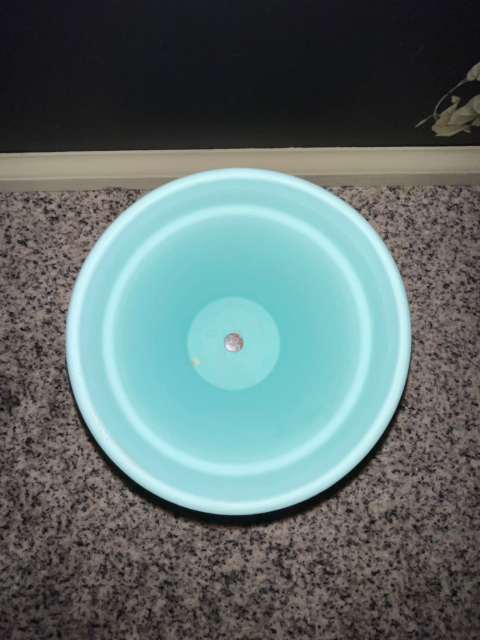 Top-down view of aqua blue planter showing drainage hole and clean interior