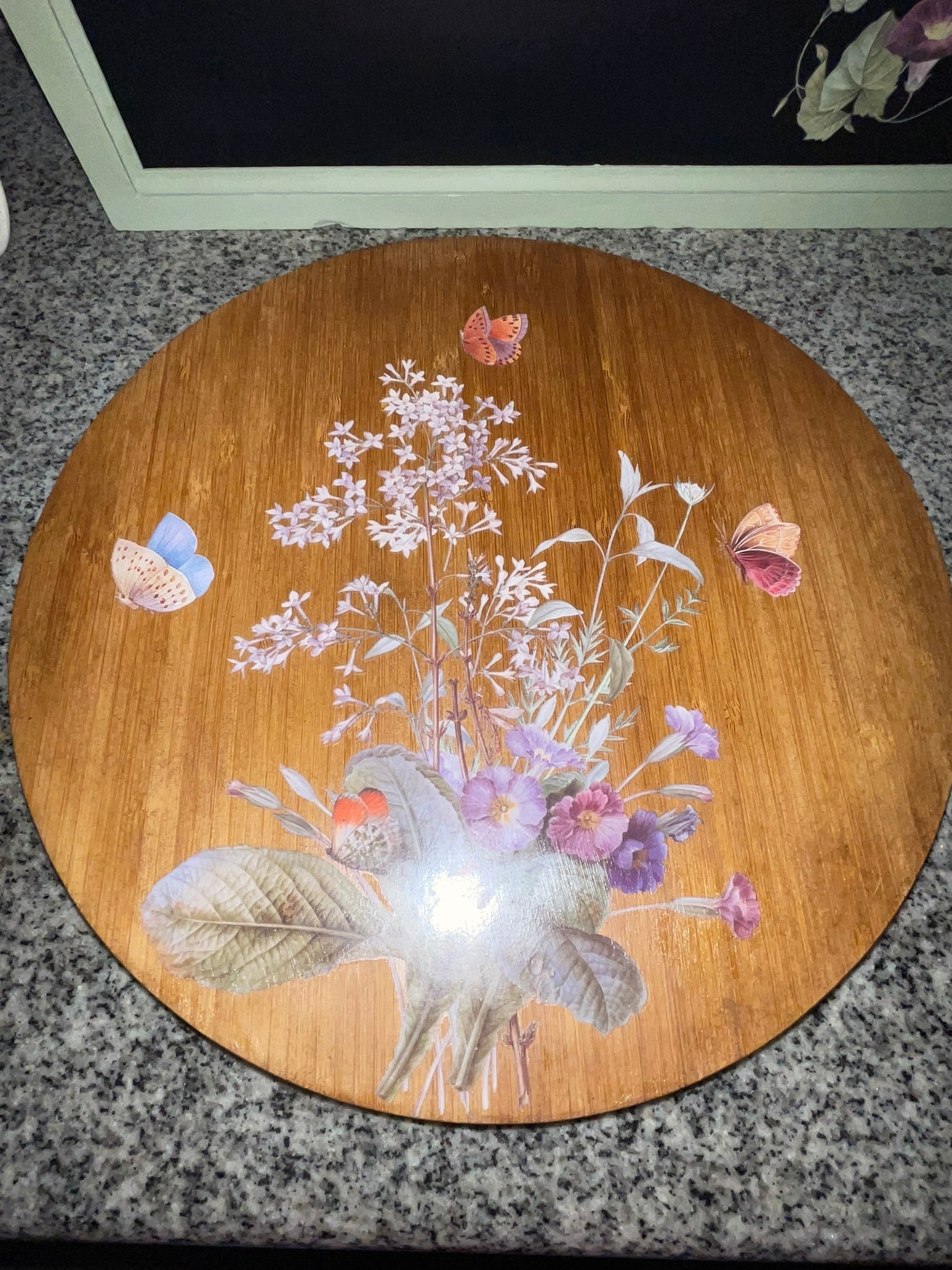 Vintage bamboo lazy Susan top view showing botanical butterfly decoupage, close-up