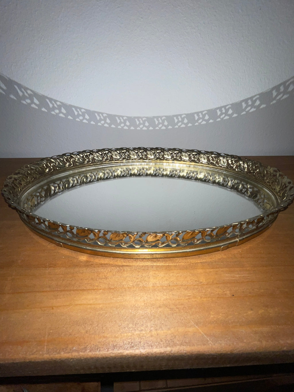 Vintage gold filigree oval mirror vanity tray, straight-on front view showing full filigree rim