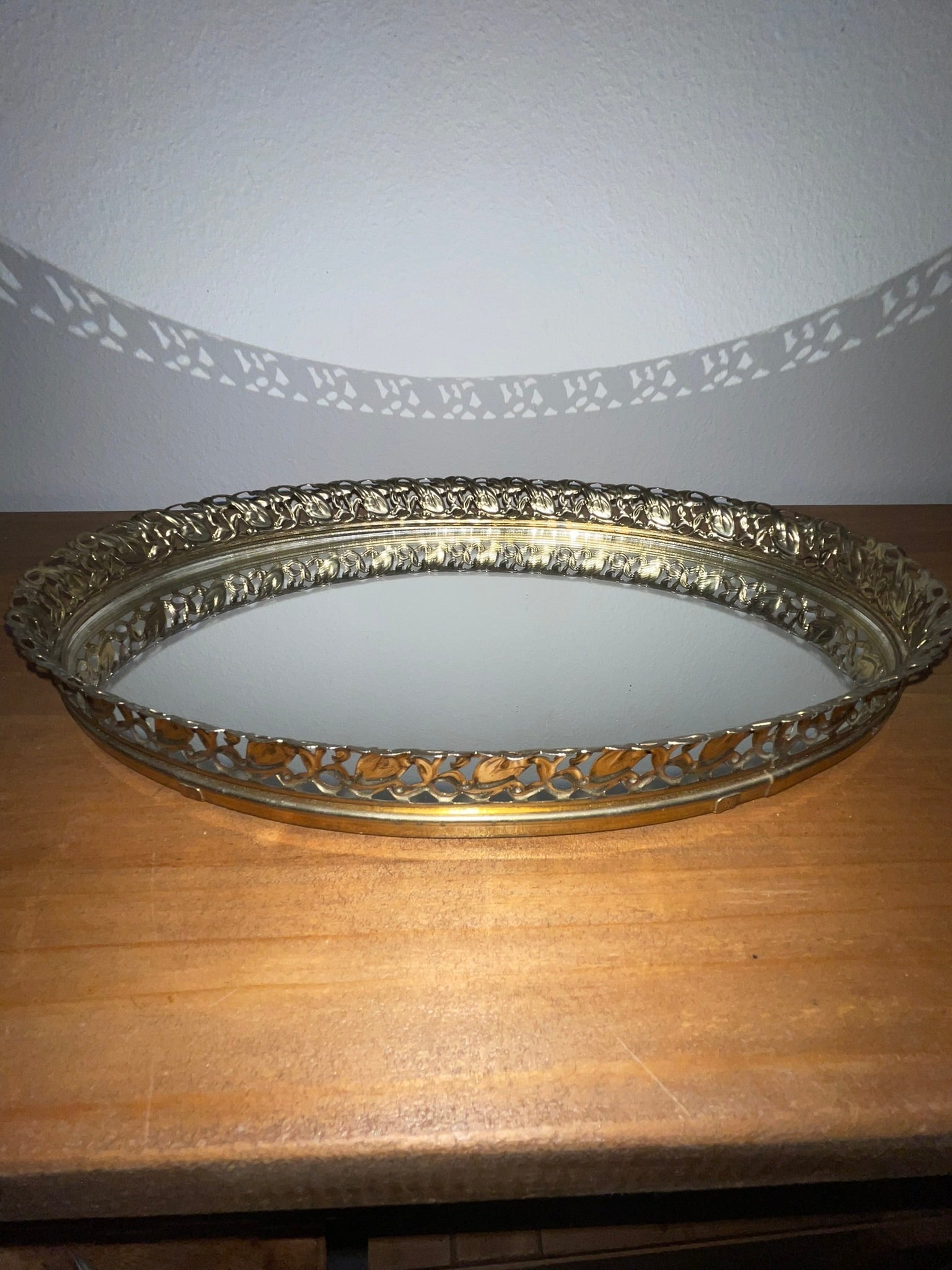 Vintage gold filigree oval mirror vanity tray, straight-on front view showing full filigree rim