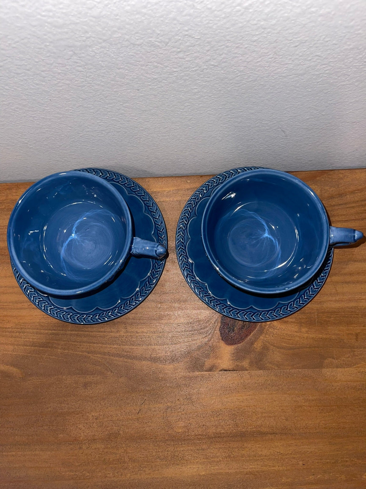 Overhead view of two Athens Blue cups and saucers showing embossed laurel border