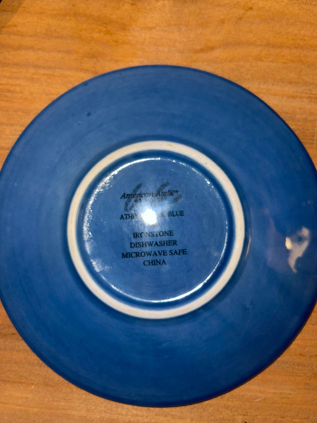 Backstamp of American Atelier Athens Blue ironstone saucer showing dishwasher and microwave safe