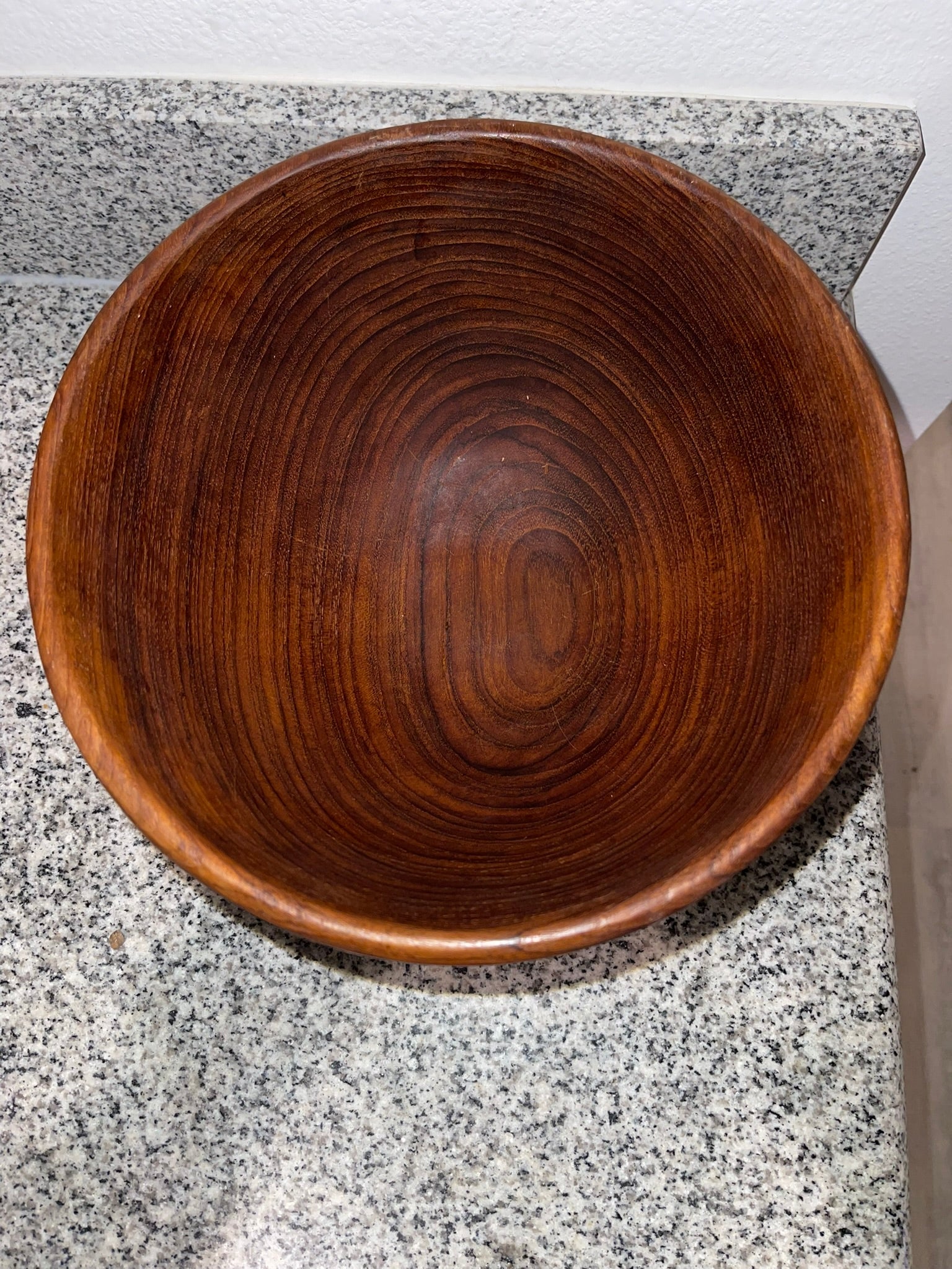 Side view of teak wood bowl showing organic silhouette and grain
